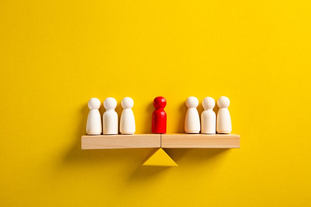 The leader stands on the scales between two groups of people. Resolving conflict situations
